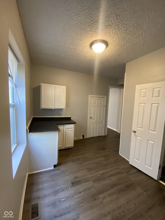 653 Birch Ave, Indianapolis, IN 46221 - laundry area with dark wood-style floors, a textured ceiling, and baseboards