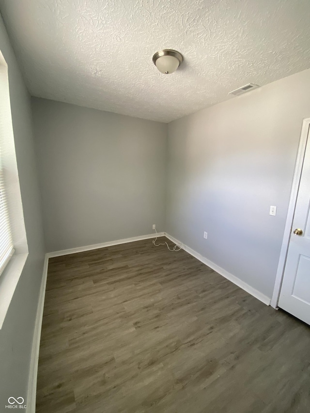 653 Birch Ave, Indianapolis, IN 46221 - spare room featuring dark wood-style floors, a textured ceiling, and baseboards