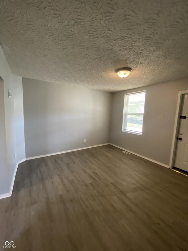 653 Birch Ave, Indianapolis, IN 46221 - spare room with dark wood finished floors, baseboards, and a textured ceiling