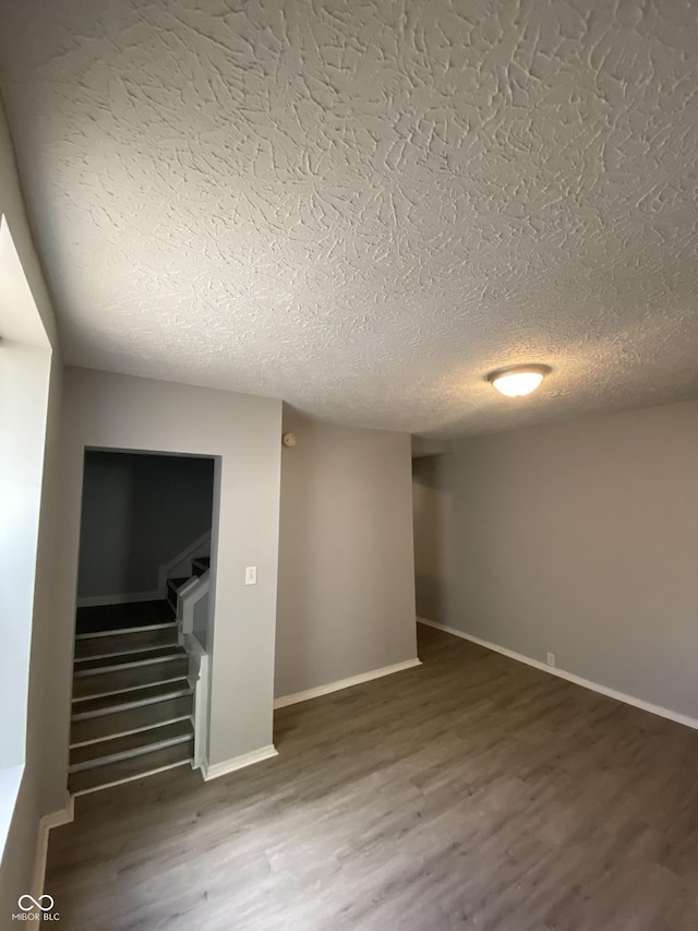 653 Birch Ave, Indianapolis, IN 46221 - basement featuring wood finished floors, a textured ceiling, stairs, and baseboards