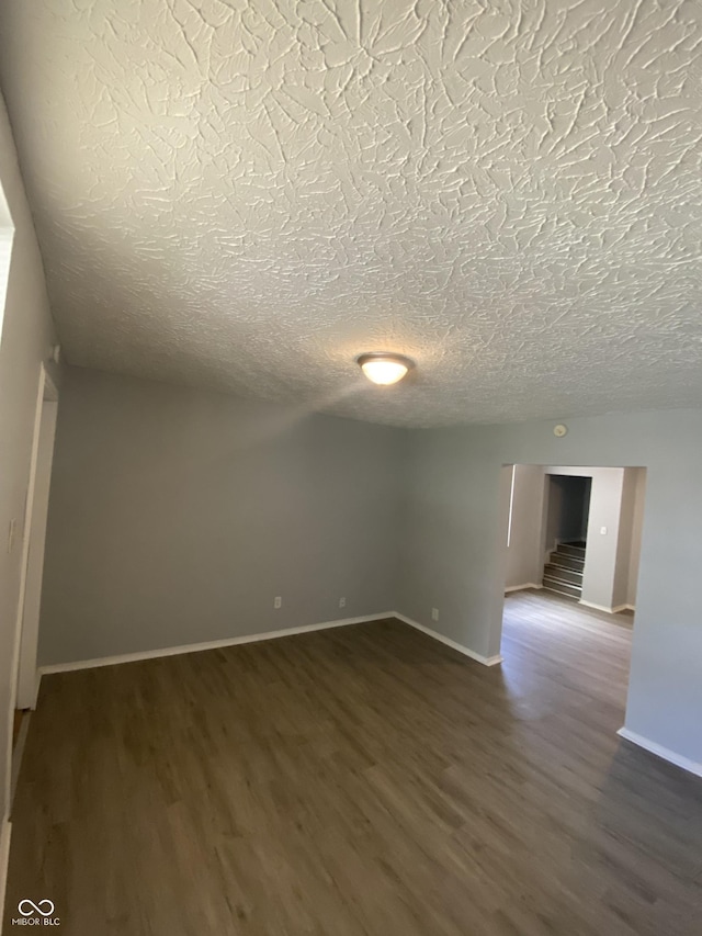 653 Birch Ave, Indianapolis, IN 46221 - empty room with dark wood-style floors, a textured ceiling, and baseboards