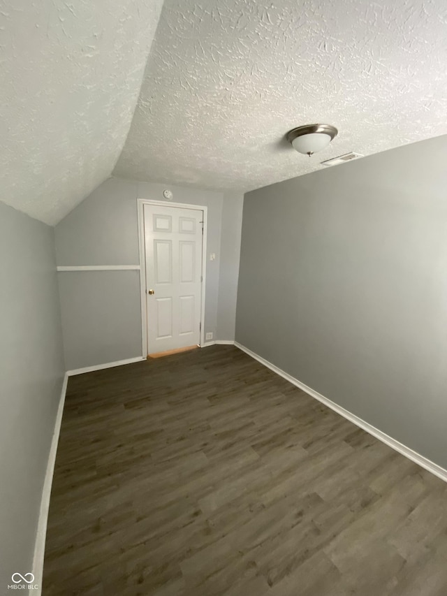 653 Birch Ave, Indianapolis, IN 46221 - additional living space with a textured ceiling, baseboards, wood finished floors, and lofted ceiling