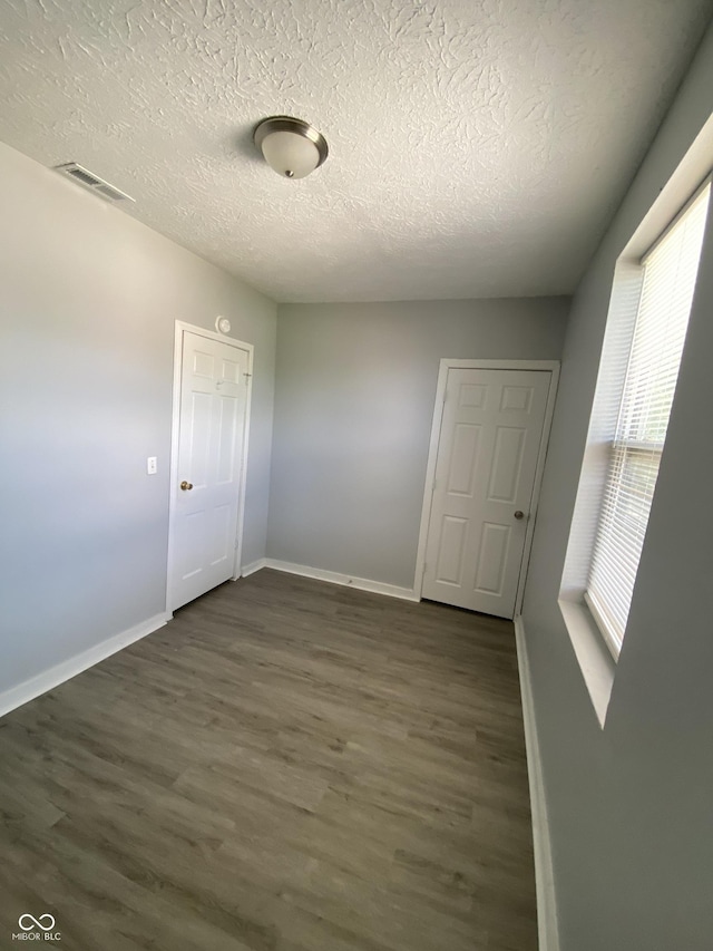 653 Birch Ave, Indianapolis, IN 46221 - spare room with dark wood finished floors, a textured ceiling, and baseboards