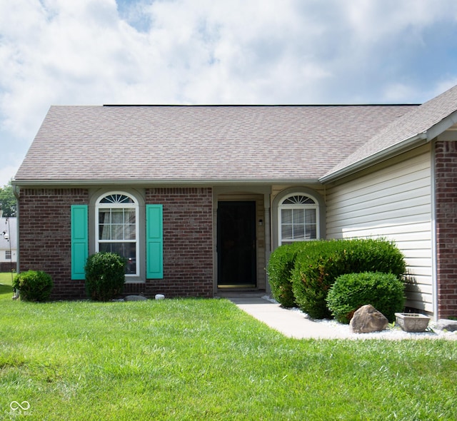 540 Cahill Ln, Indianapolis, IN 46214 - view of front facade featuring roof with shingles, a front yard, and brick siding