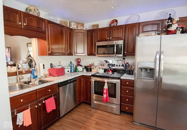 540 Cahill Ln, Indianapolis, IN 46214 - kitchen with appliances with stainless steel finishes, light countertops, light wood finished floors, and a textured ceiling