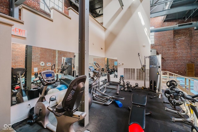 611 N Park Ave Unit 108, Indianapolis, IN 46204 - workout area with a towering ceiling and brick wall