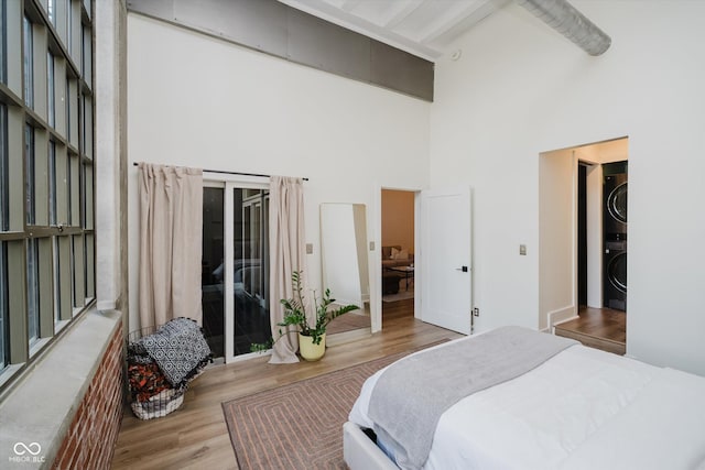 611 N Park Ave Unit 108, Indianapolis, IN 46204 - bedroom featuring estacked washer and dryer, high vaulted ceiling, wood finished floors, beamed ceiling, and access to outside