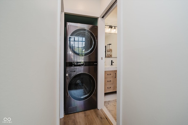 611 N Park Ave Unit 108, Indianapolis, IN 46204 - laundry area featuring estacked washer and dryer and wood finished floors