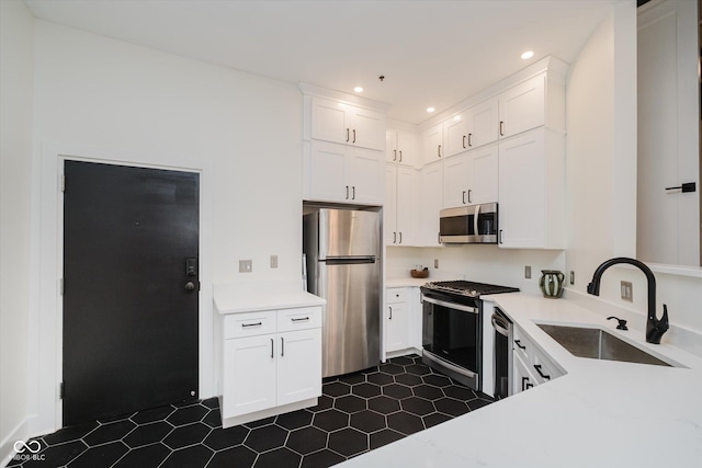 611 N Park Ave Unit 108, Indianapolis, IN 46204 - kitchen featuring appliances with stainless steel finishes, a sink, white cabinets, light countertops, and recessed lighting
