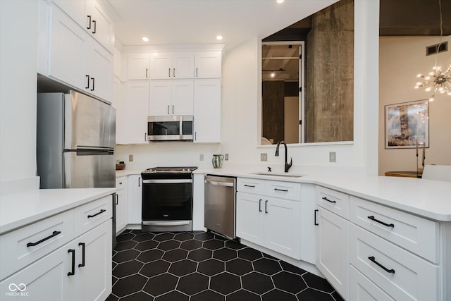 611 N Park Ave Unit 108, Indianapolis, IN 46204 - kitchen featuring appliances with stainless steel finishes, a peninsula, a sink, dark tile patterned flooring, and light countertops