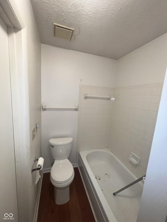 5711 Bradston Way, Indianapolis, IN 46237 - full bathroom with wood finished floors, toilet, a tub to relax in, a textured ceiling, and baseboards
