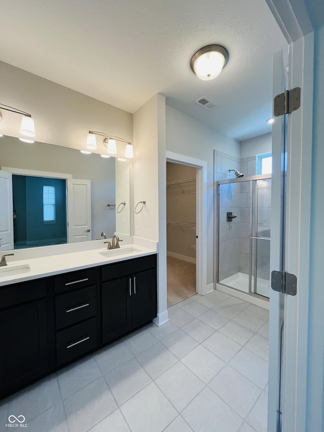 17399 Dovehouse Ln, Westfield, IN 46074 - bathroom with a shower stall, double vanity, tile patterned flooring, a walk in closet, and baseboards