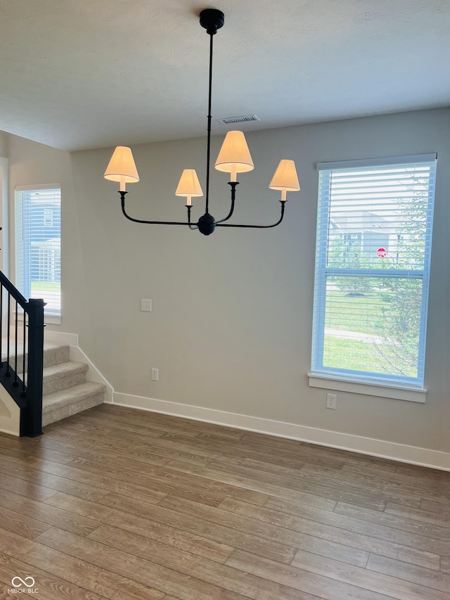 17399 Dovehouse Ln, Westfield, IN 46074 - unfurnished room with hardwood / wood-style floors, stairs, baseboards, and a chandelier