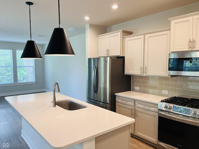 17399 Dovehouse Ln, Westfield, IN 46074 - kitchen with stainless steel appliances, a sink, light wood-style flooring, tasteful backsplash, and light countertops