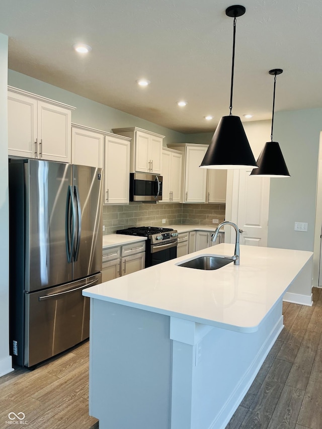 17399 Dovehouse Ln, Westfield, IN 46074 - kitchen with stainless steel appliances, a sink, light wood-style floors, white cabinets, and recessed lighting