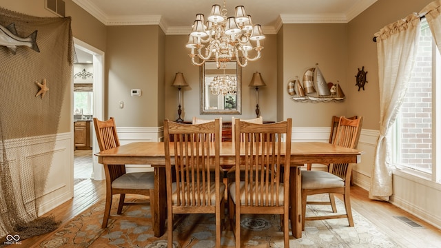 12539 Pebblepointe Pass, Carmel, IN 46033 - dining room with light wood-type flooring, a chandelier, a wainscoted wall, ornamental molding, and a decorative wall