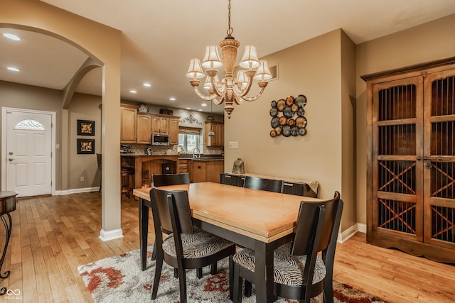 12539 Pebblepointe Pass, Carmel, IN 46033 - dining room with arched walkways, light wood-style flooring, a chandelier, baseboards, and recessed lighting