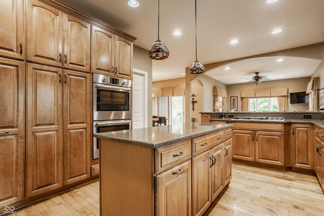 12539 Pebblepointe Pass, Carmel, IN 46033 - kitchen with stainless steel appliances, light wood-style floors, a kitchen island, a ceiling fan, and recessed lighting