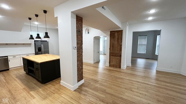 909 N Temple Ave, Indianapolis, IN 46201 - kitchen featuring appliances with stainless steel finishes, arched walkways, light wood finished floors, hanging light fixtures, and recessed lighting