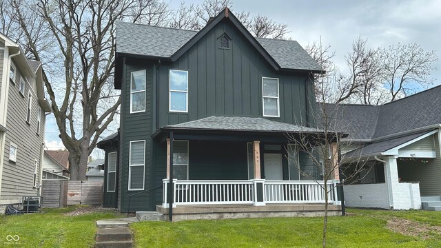 909 N Temple Ave, Indianapolis, IN 46201 - view of front of house featuring a porch, board and batten siding, a front lawn, and roof with shingles