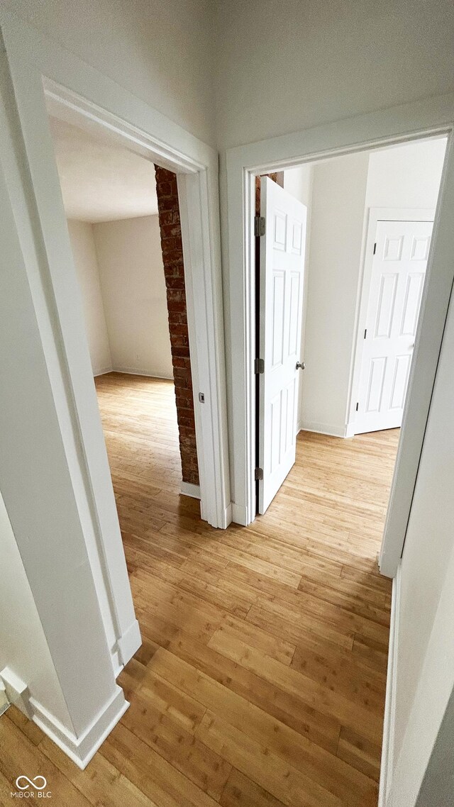909 N Temple Ave, Indianapolis, IN 46201 - hall with light wood finished floors, decorative columns, and baseboards