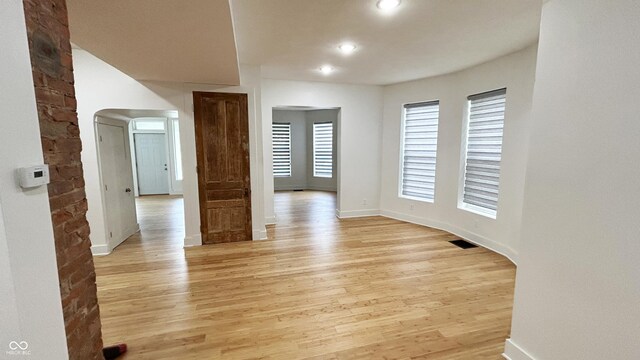 909 N Temple Ave, Indianapolis, IN 46201 - spare room featuring light wood-style flooring, baseboards, recessed lighting, and arched walkways
