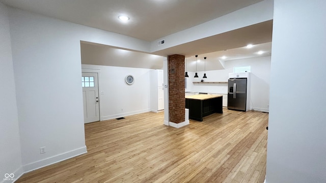 909 N Temple Ave, Indianapolis, IN 46201 - kitchen with stainless steel fridge, light countertops, light wood-type flooring, baseboards, and recessed lighting