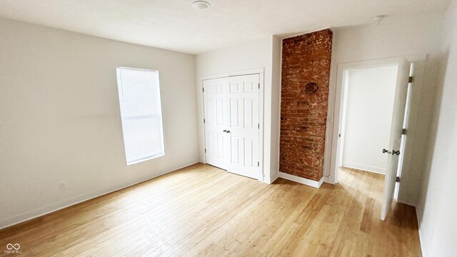 909 N Temple Ave, Indianapolis, IN 46201 - unfurnished bedroom featuring light wood-type flooring, a closet, and baseboards