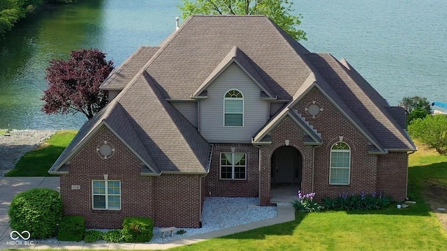 719 E New Rd, Greenfield, IN 46140 - view of front of home with brick siding, a front lawn, a water view, and a patio area