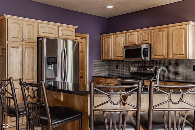 719 E New Rd, Greenfield, IN 46140 - kitchen with stainless steel appliances, a kitchen breakfast bar, dark countertops, and decorative backsplash