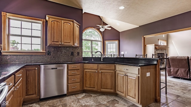 719 E New Rd, Greenfield, IN 46140 - kitchen with stainless steel dishwasher, lofted ceiling, a kitchen breakfast bar, a ceiling fan, and a peninsula