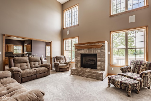 719 E New Rd, Greenfield, IN 46140 - living area with plenty of natural light, light carpet, a fireplace, and a towering ceiling