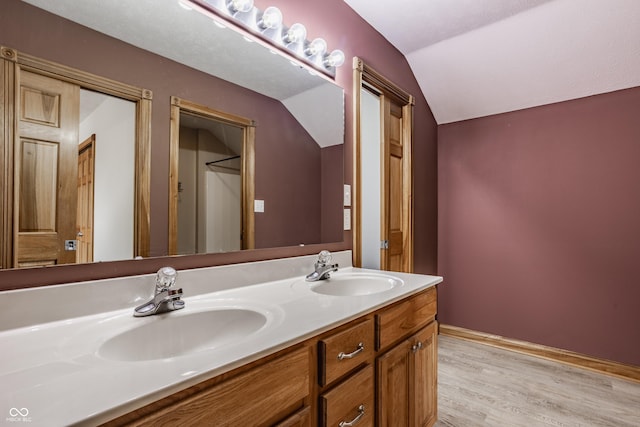 719 E New Rd, Greenfield, IN 46140 - full bathroom with lofted ceiling, double vanity, wood finished floors, and baseboards