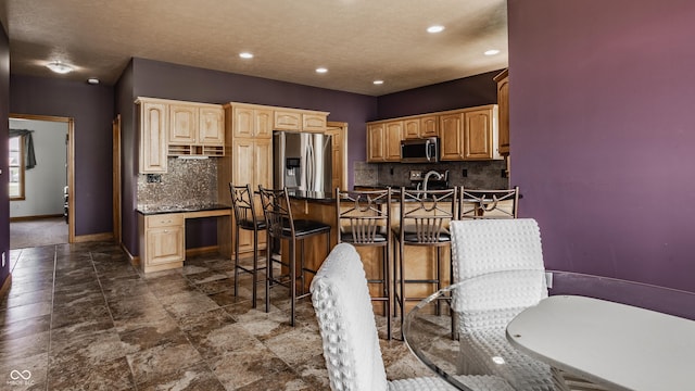 719 E New Rd, Greenfield, IN 46140 - kitchen featuring appliances with stainless steel finishes, dark countertops, backsplash, a kitchen bar, and baseboards