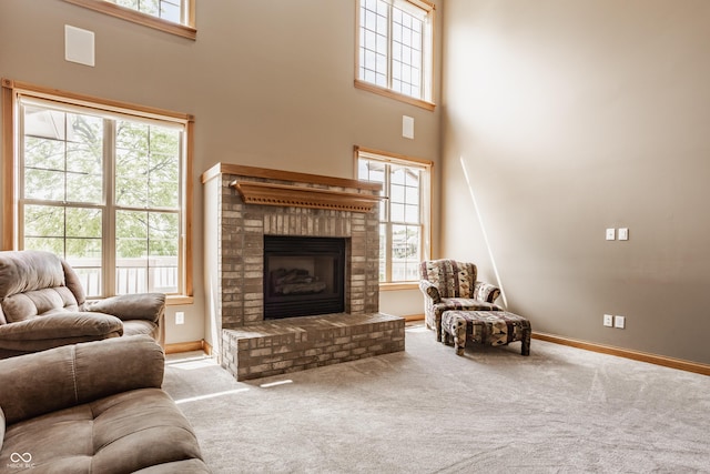 719 E New Rd, Greenfield, IN 46140 - living room featuring a fireplace, carpet flooring, baseboards, and a towering ceiling