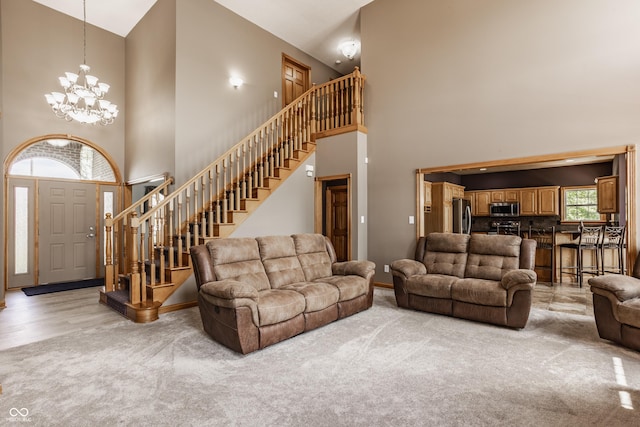 719 E New Rd, Greenfield, IN 46140 - living room with a high ceiling, light carpet, a chandelier, stairs, and baseboards