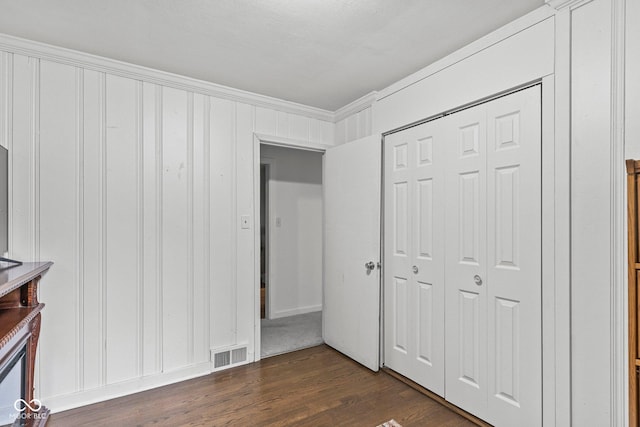 426 Tipton Ln, Columbus, IN 47201 - unfurnished bedroom featuring dark wood-style floors, crown molding, and a closet