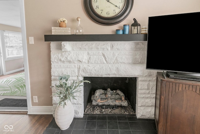 426 Tipton Ln, Columbus, IN 47201 - detailed view of a stone fireplace, baseboards, and wood finished floors