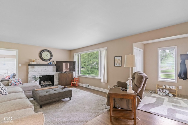 426 Tipton Ln, Columbus, IN 47201 - living area with wood finished floors, a stone fireplace, and baseboards