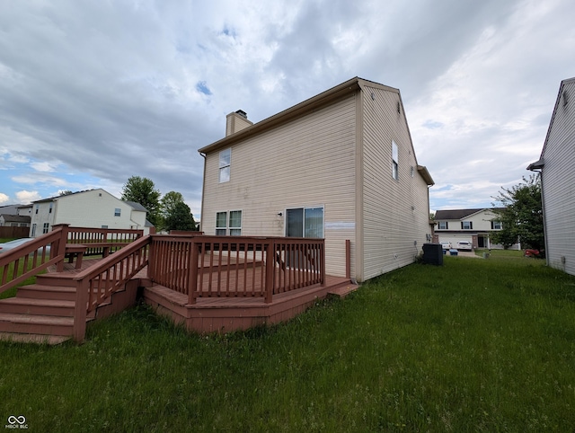 10722 Mistflower Way, Indianapolis, IN 46235 - back of house featuring a wooden deck, a chimney, a lawn, and central air condition unit