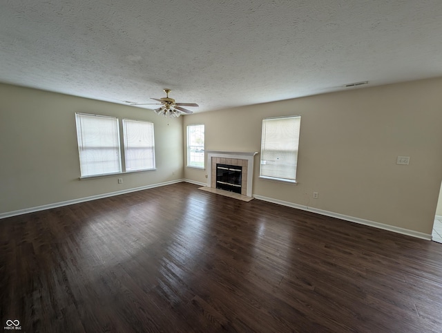 10722 Mistflower Way, Indianapolis, IN 46235 - unfurnished living room with dark wood finished floors, a textured ceiling, baseboards, a tiled fireplace, and a ceiling fan