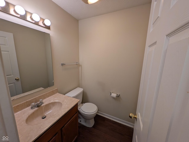 10722 Mistflower Way, Indianapolis, IN 46235 - half bath featuring toilet, wood finished floors, vanity, baseboards, and a textured ceiling
