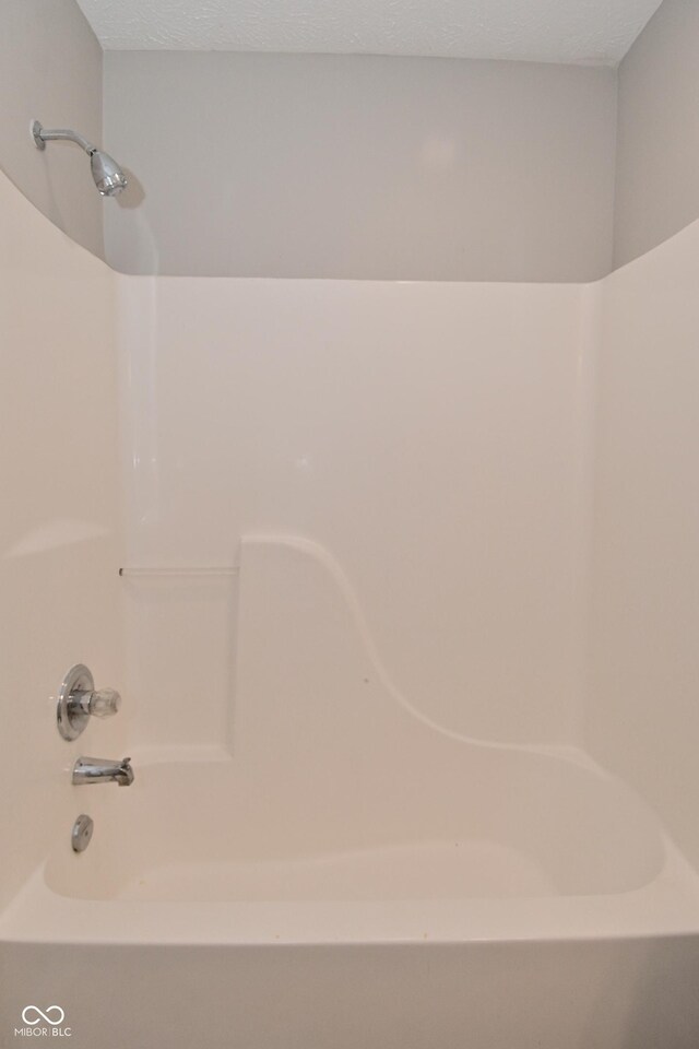 10722 Mistflower Way, Indianapolis, IN 46235 - full bathroom featuring washtub / shower combination and a textured ceiling
