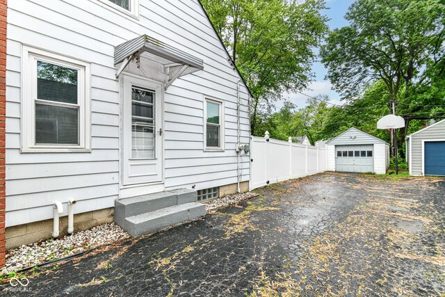 2526 Dell Zell Dr, Indianapolis, IN 46220 - view of property exterior with entry steps, a garage, an outdoor structure, and driveway
