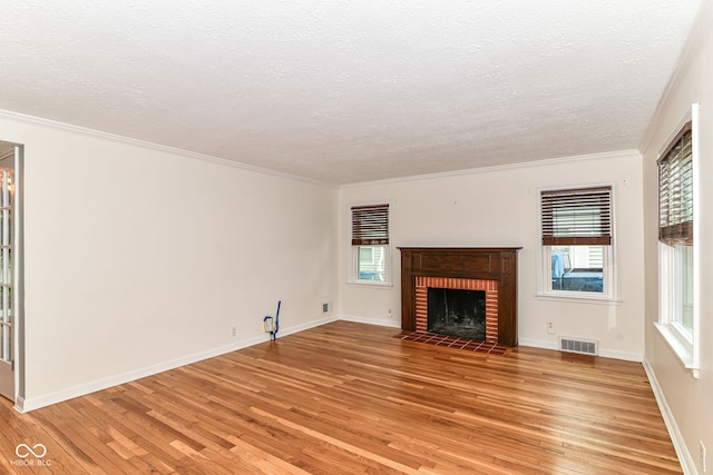 2526 Dell Zell Dr, Indianapolis, IN 46220 - unfurnished living room featuring light wood-style floors, a textured ceiling, a brick fireplace, crown molding, and baseboards