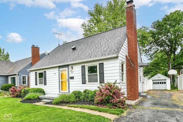 2526 Dell Zell Dr, Indianapolis, IN 46220 - view of front of house with an outbuilding, a chimney, a garage, driveway, and roof with shingles