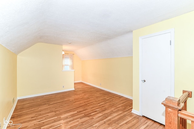 2526 Dell Zell Dr, Indianapolis, IN 46220 - bonus room featuring light wood finished floors, baseboards, a textured ceiling, and lofted ceiling