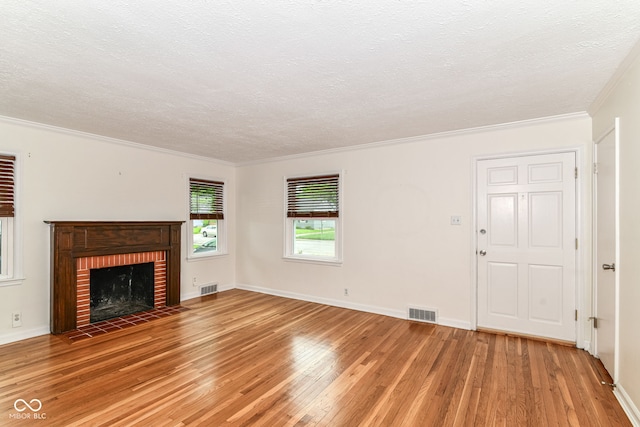 2526 Dell Zell Dr, Indianapolis, IN 46220 - unfurnished living room with light wood finished floors, a textured ceiling, ornamental molding, a brick fireplace, and baseboards
