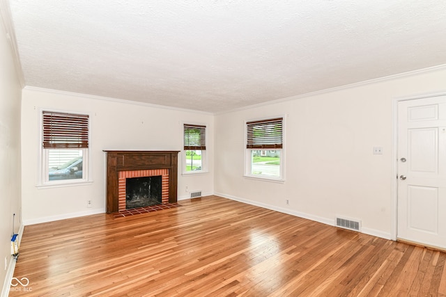 2526 Dell Zell Dr, Indianapolis, IN 46220 - unfurnished living room featuring light wood finished floors, a textured ceiling, crown molding, a brick fireplace, and baseboards
