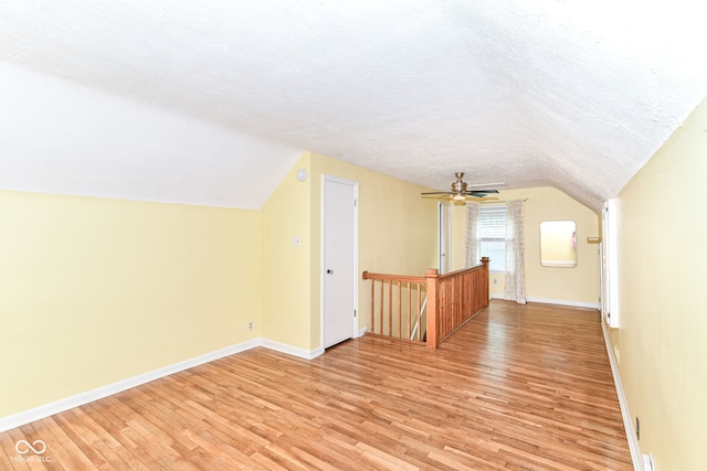2526 Dell Zell Dr, Indianapolis, IN 46220 - bonus room featuring light wood-type flooring, baseboards, vaulted ceiling, a textured ceiling, and ceiling fan